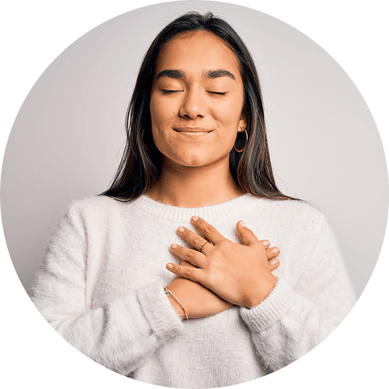 Woman with her eyes closed and hands over heart